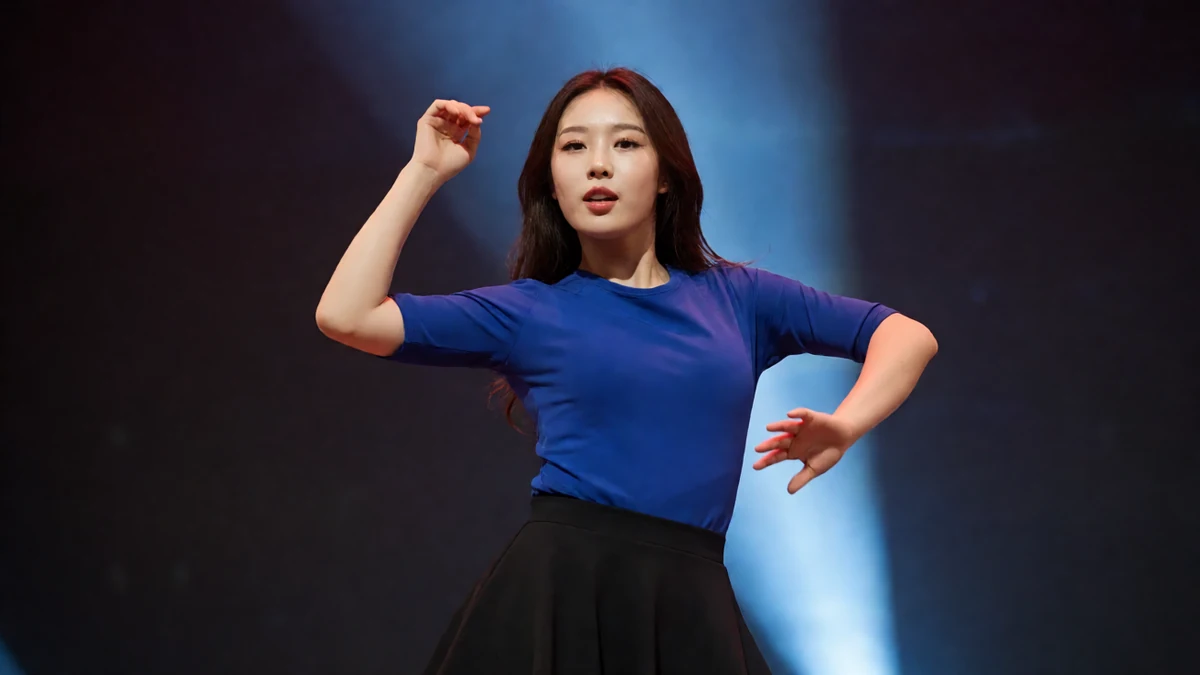 美女热舞全集独舞图,成年舞者穿亮蓝上衣与黑短裙在聚光灯下迈步